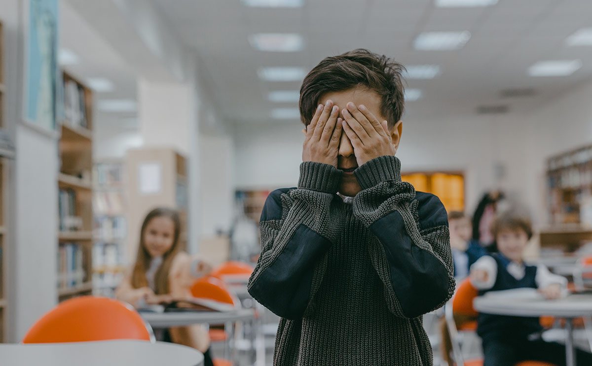 طفل في المدرسة يُغمض عينيه بسبب تعرّضه للتنمّر