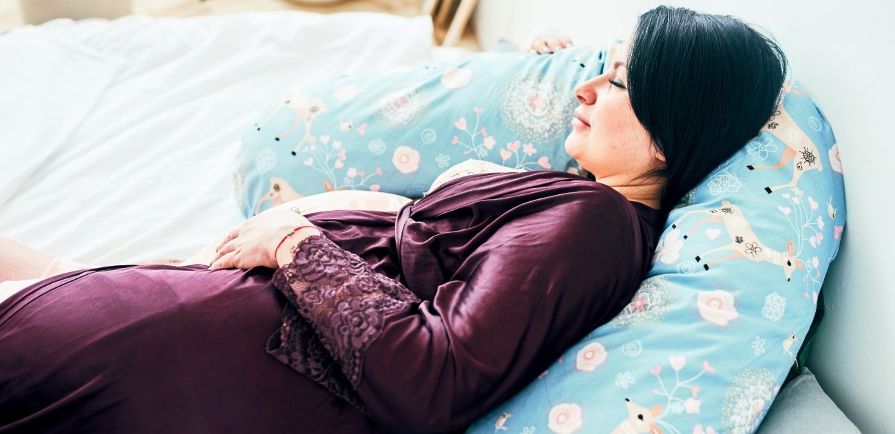 امرأة حامل تستلقي على وسادة الحمل
