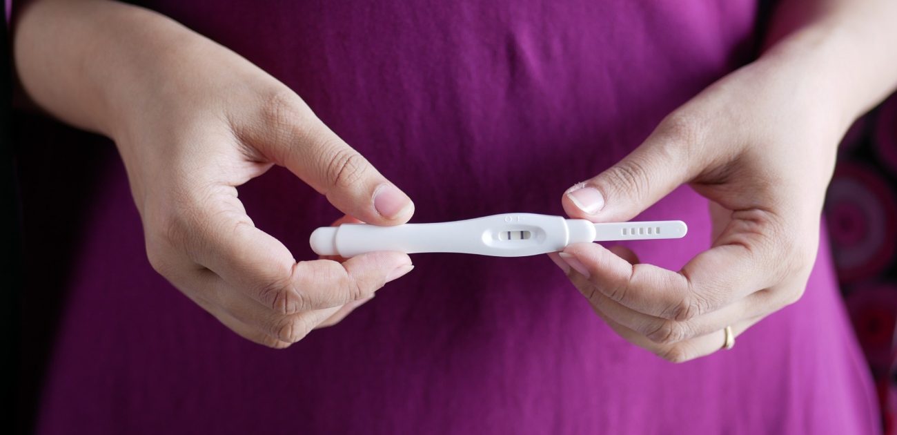 امرأة تمسك اختبار حمل