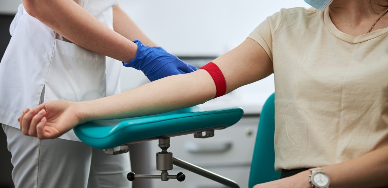 ممرّضة تُجري فحص دم لمريضة