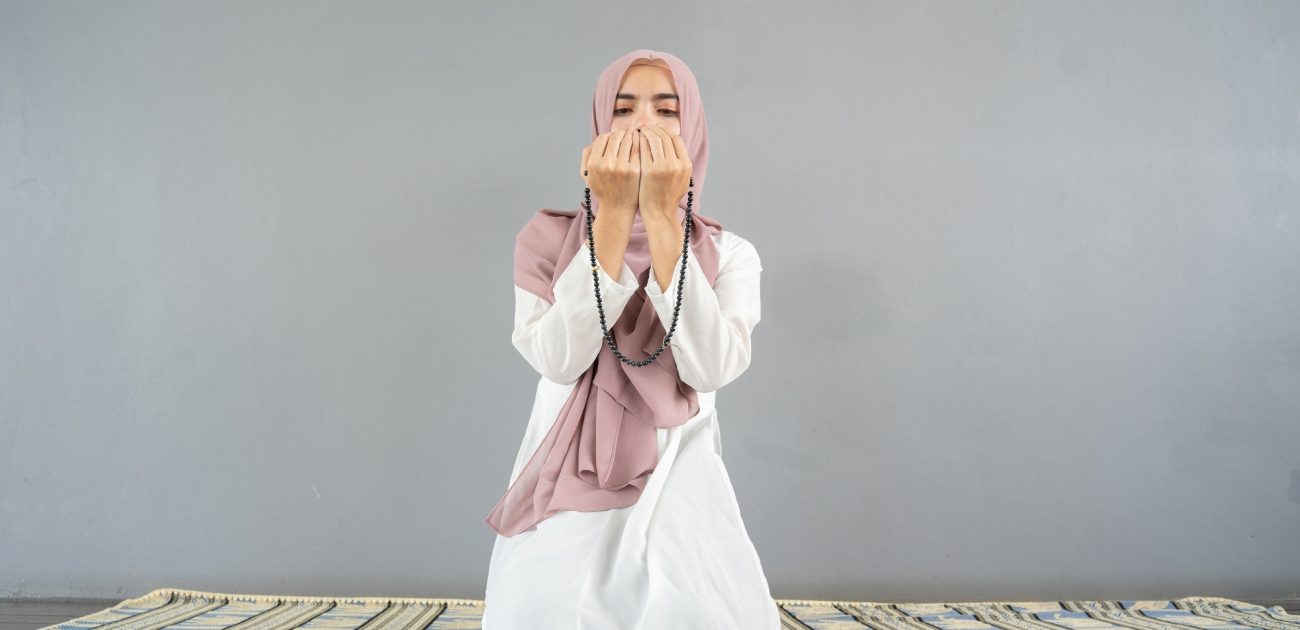 امرأة مسلمة ترفع يديها للدعاء