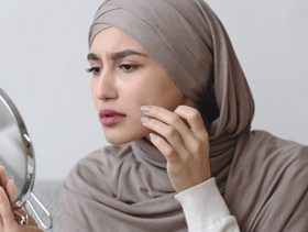 امرأة تنظر في مرآتها