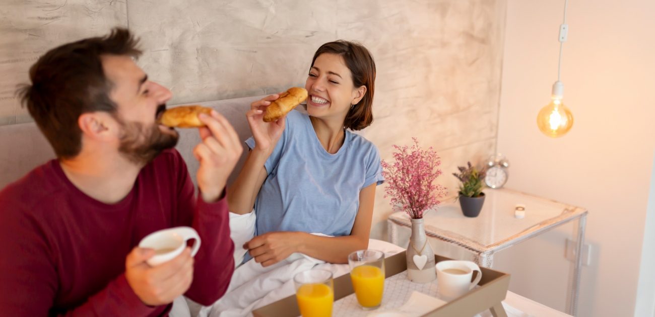 امرأة ورجل يتناولان الفطور في السرير