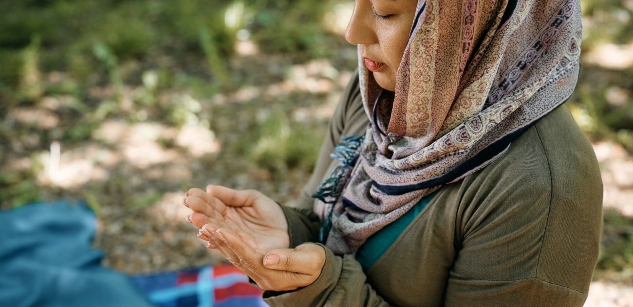 امرأة مسلمة ترفع يديها للدعاء