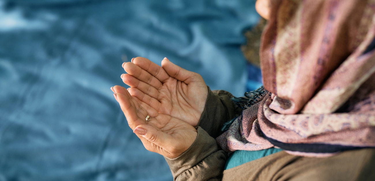 امراة ترفع يديها للدعاء
