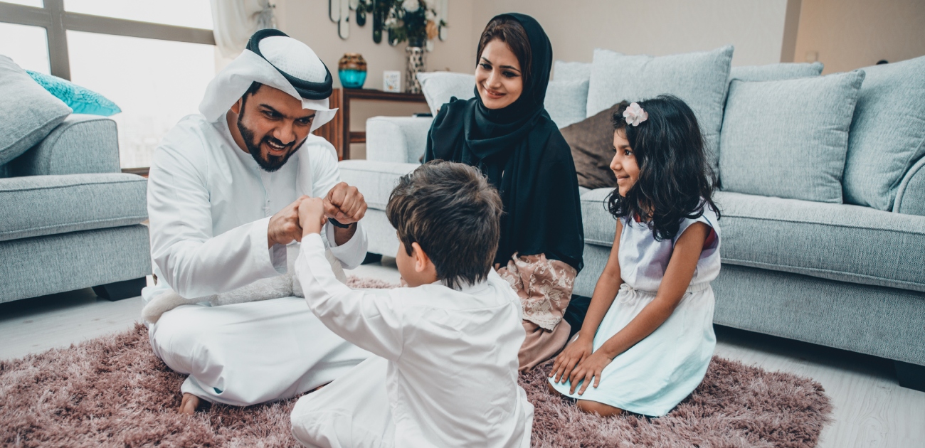 أفراد العائلة يجلسون بفرح على الأرض
