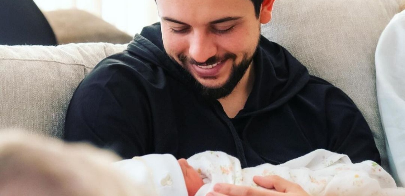 الأمير الحسين يحمل ابنته الأميرة ايمان