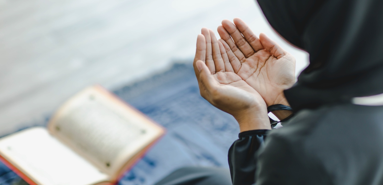 امرأة ترفع يديها بالدعاء