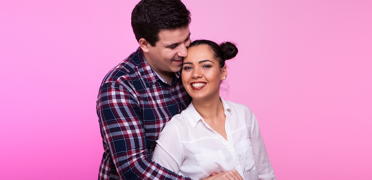 رجل يعانق زوجته من الخلف بسعادة
