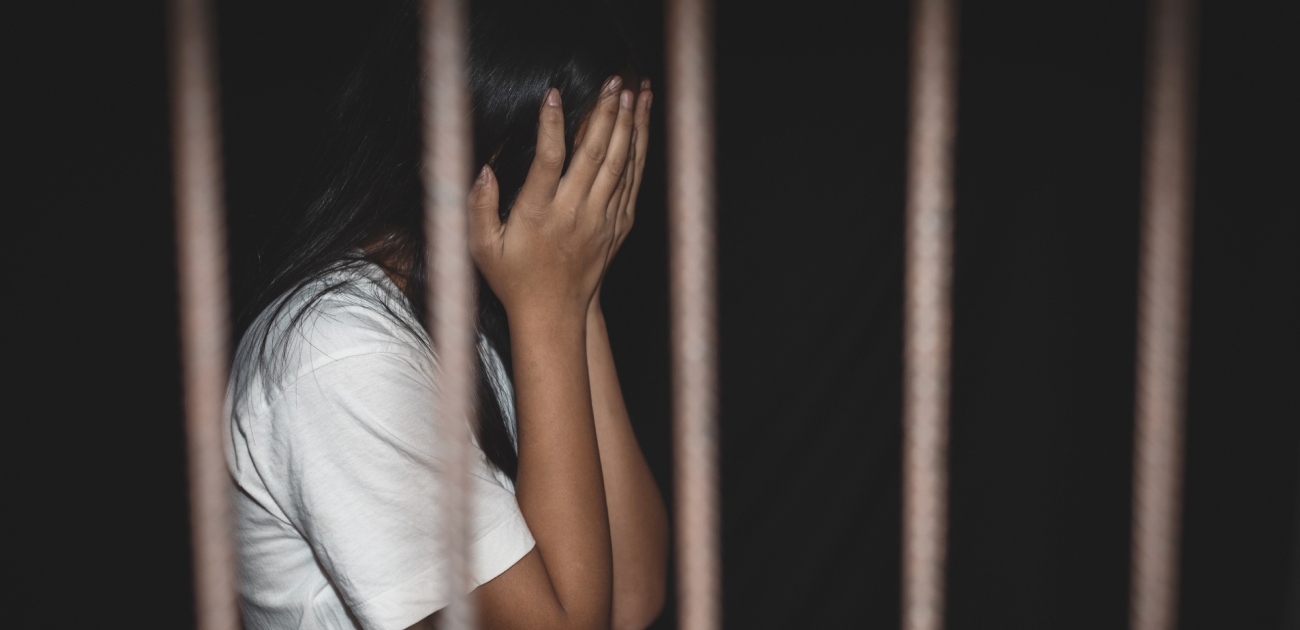 امرأة داخل السجن تضع يديها على وجهها