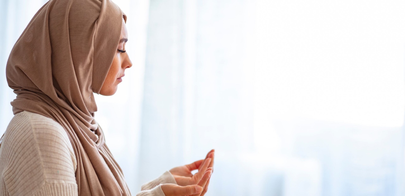 امرأة ترفع يديها بالدعاء