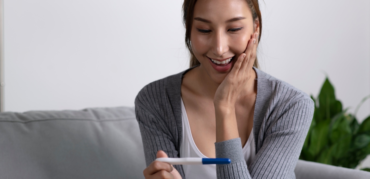 امرأة متفاجئة تمسك اختبار حمل