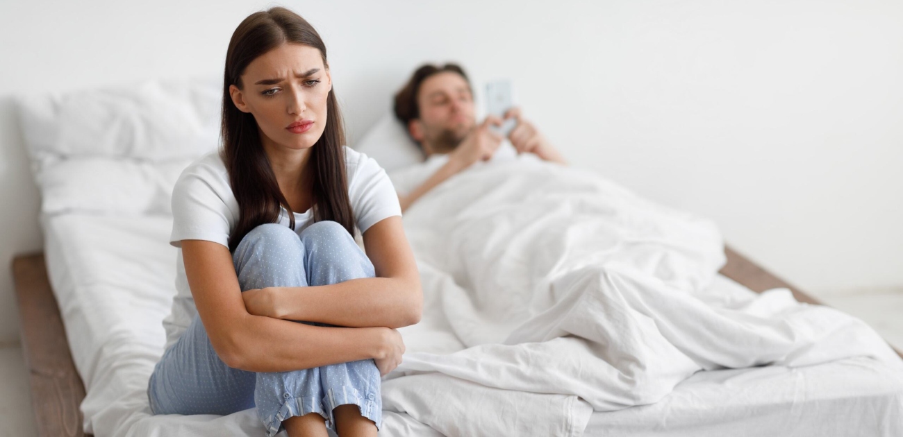 امرأة تجلس حزينة فب الفراش