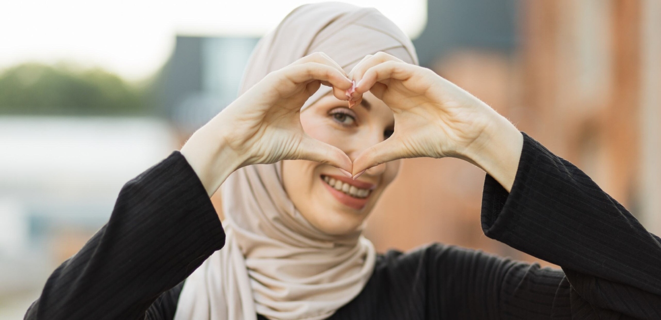 امرأة ترمز بيديها إلى الحب