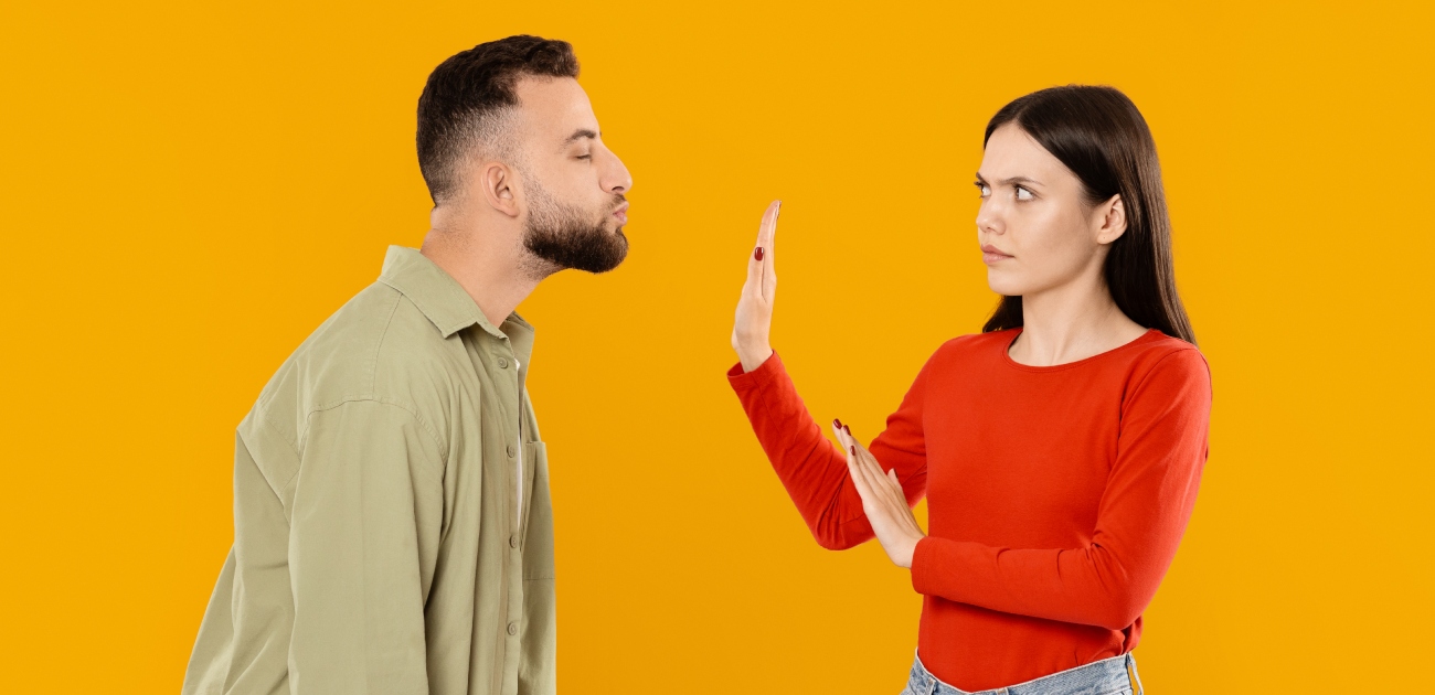رجل يحاول أن يقبّل امرأة وهي تصدّه