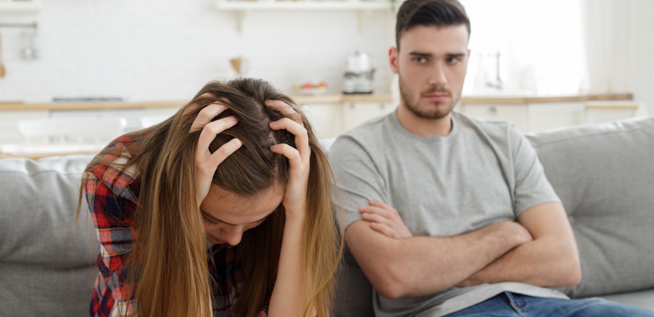 امرأة حزينة وزوجها بجانبها ينظر إليها