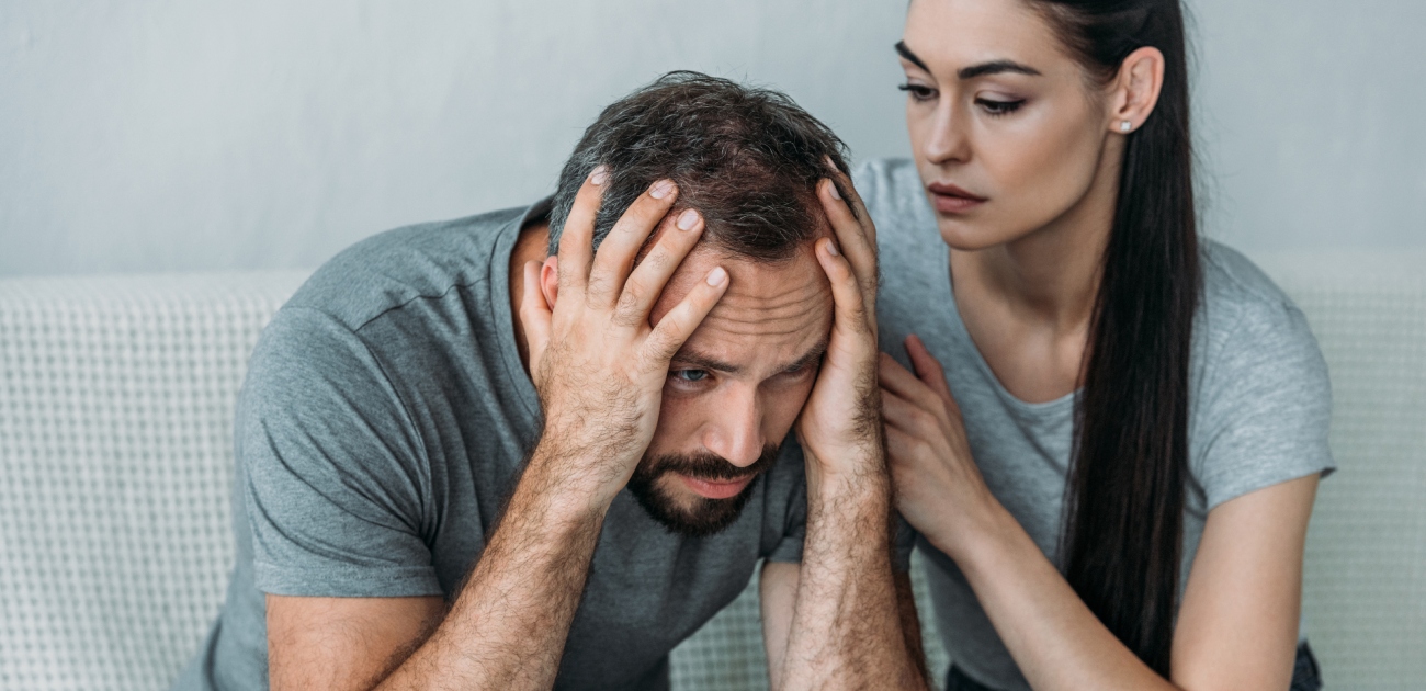 رجل حزين وامرأة تحاول التقرّب منه