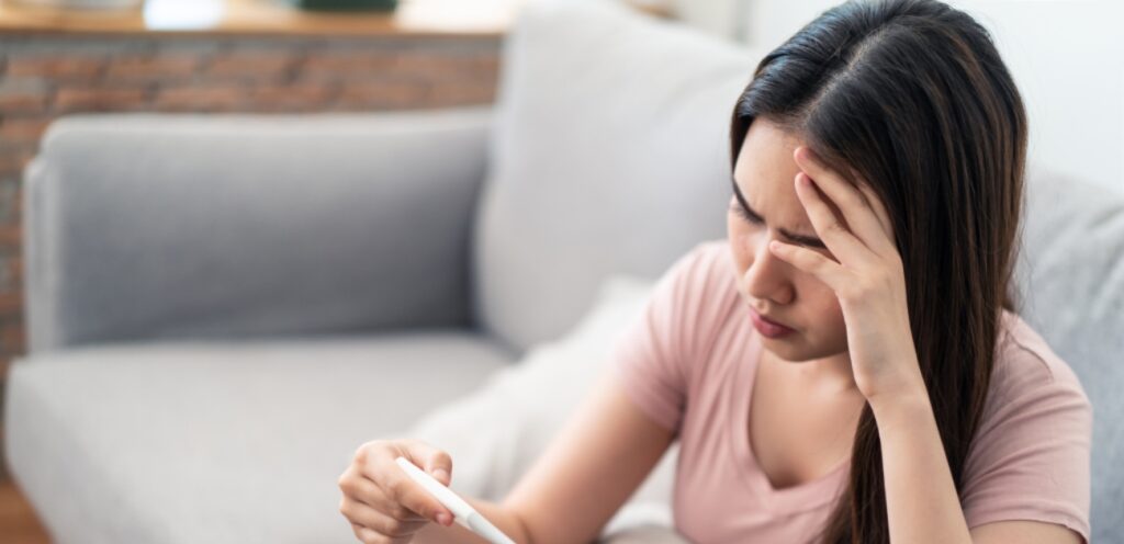 امرأة تمسك اختبار حمل
